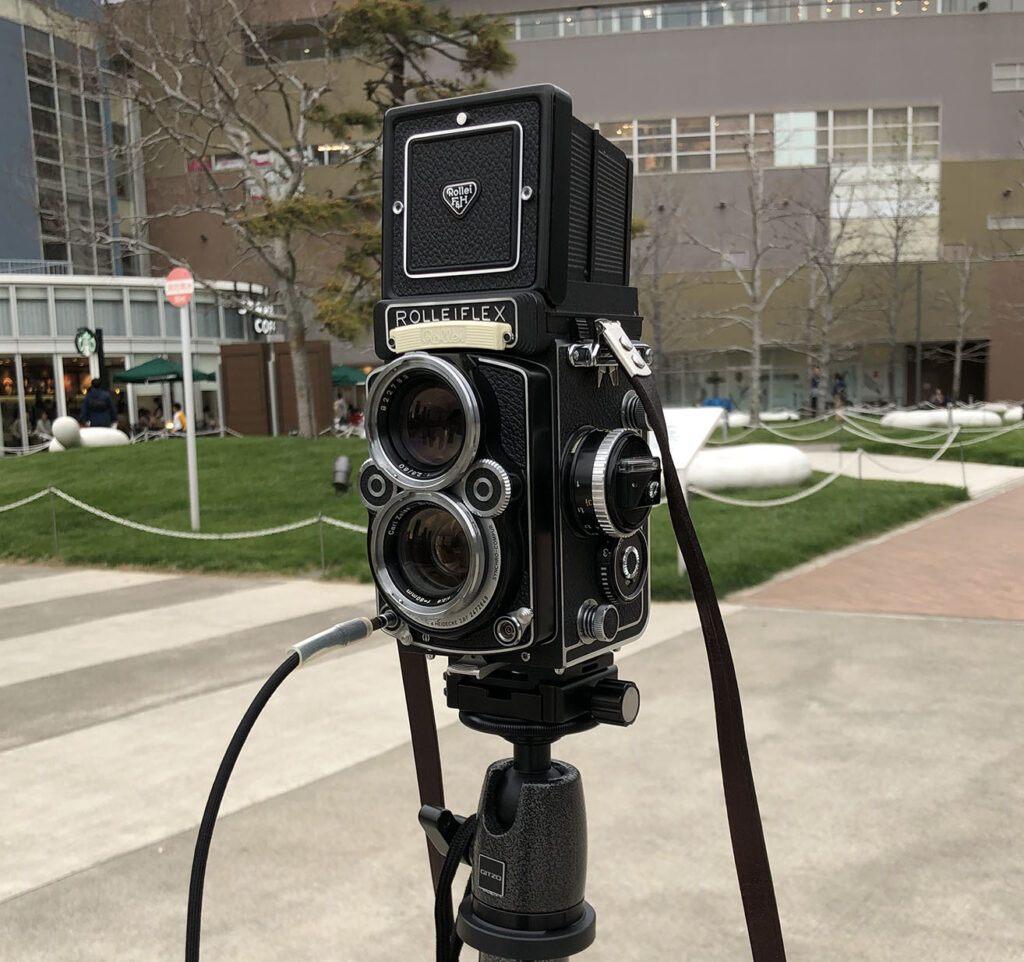 屋外で三脚に載せたRolleiflex二眼レフカメラ。中判カメラで写真を撮る目標の象徴